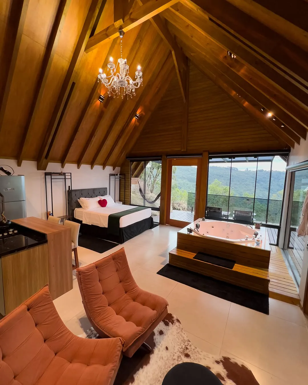 Cabana da Pedra — estar com poltronas e vista para a montanha
