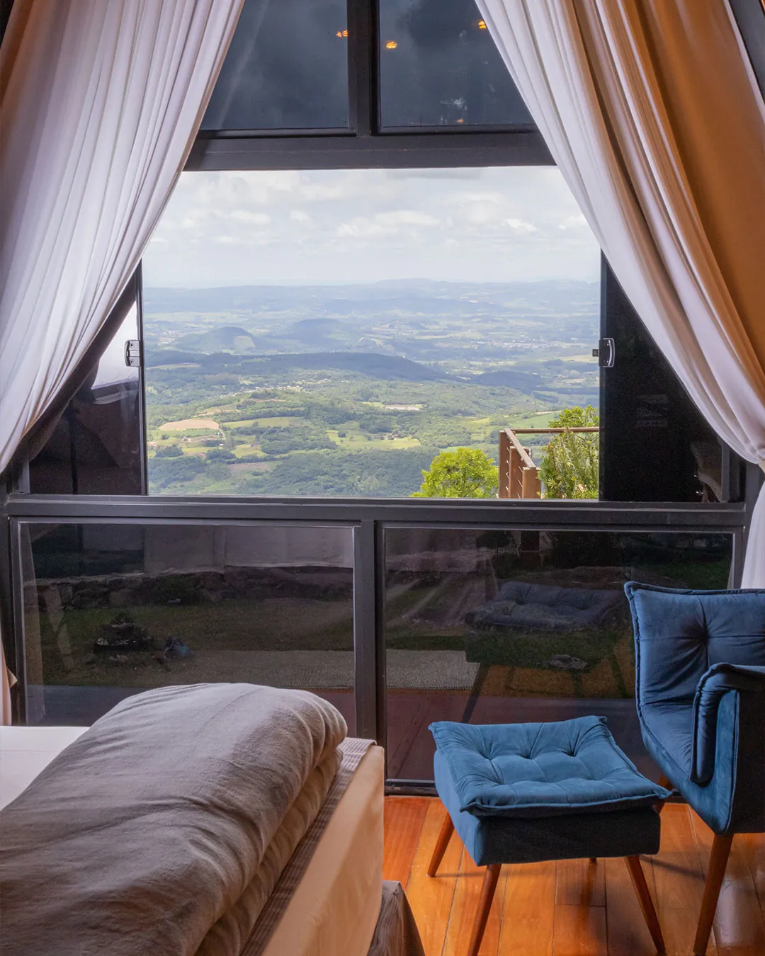 Cabana dos Sonhos — janela aberta para o vale, com poltrona